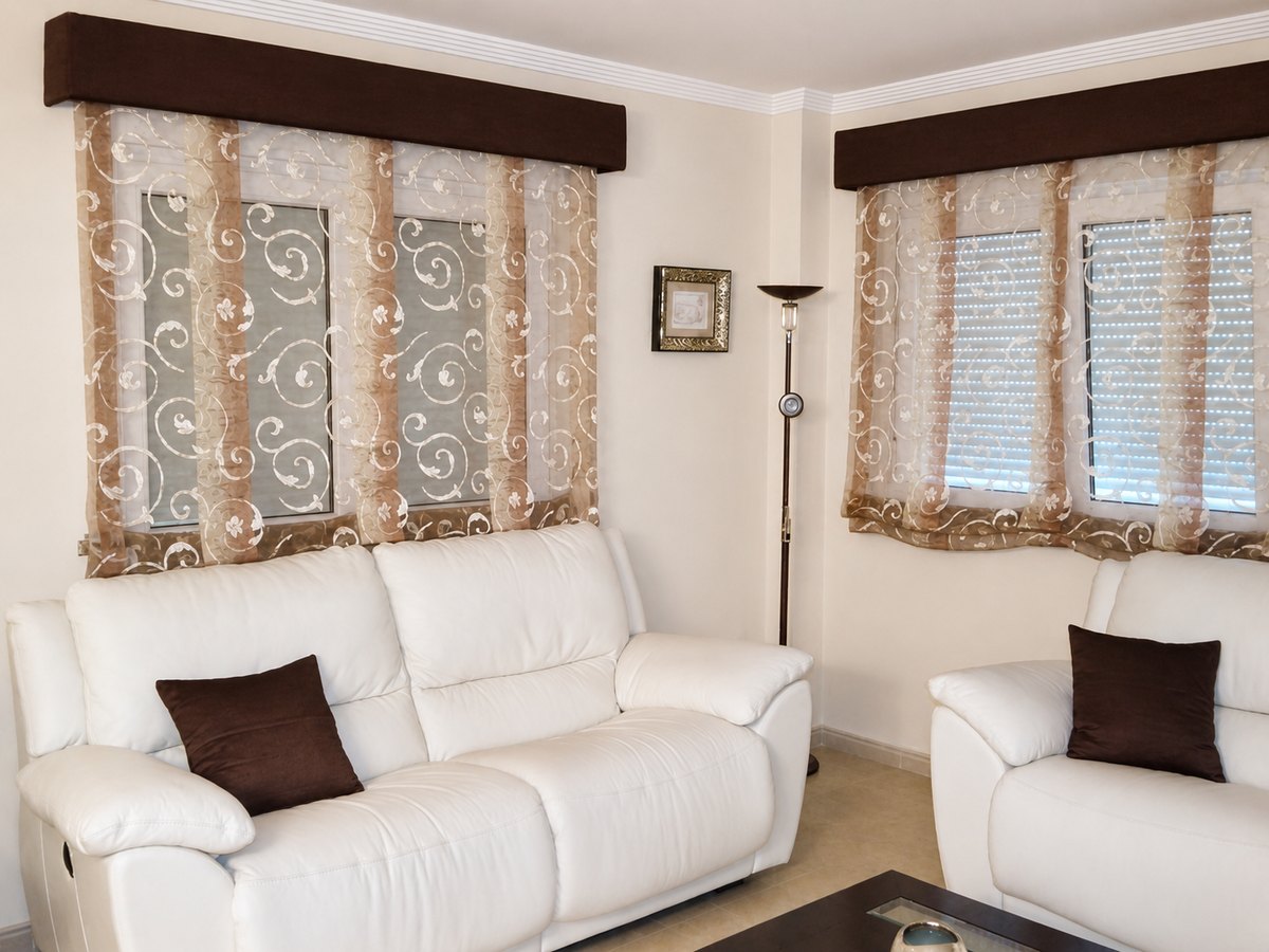 Salón con visillos y bandós a medida sobre dos ventanas